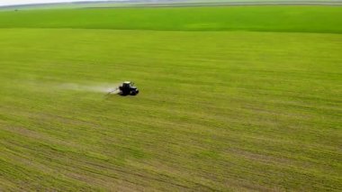 Traktörde soya tarlaları püskürten çiftçinin insansız hava aracı görüntüleri.