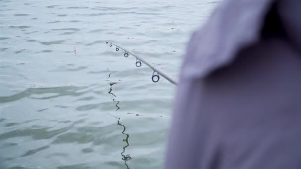 Mulher adulta pesca no rio com haste flutuante em tempo nublado frio — Vídeo de Stock