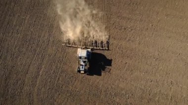 Traktörün kuru ve tozlu tarım tarlalarını sürerken ve toprağı ekime hazırlarken üst görüntüsü
