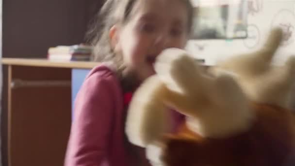 Bella bambina cavalca peluche cervo sedia a dondolo in camera dei bambini — Video Stock