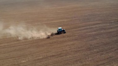 Tozlu alandaki traktörün hava görüntüsü. Disk harrow tohum için toprak hazırlıyor.
