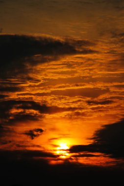 Dağların üzerinde bulutların arasında gün batımı