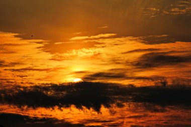 Dağların üzerinde bulutların arasında gün batımı