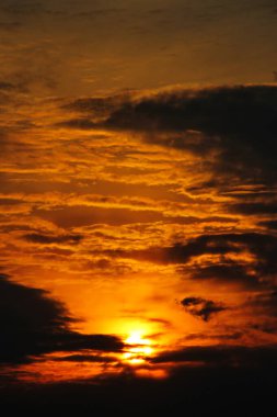 Dağların üzerinde bulutların arasında gün batımı