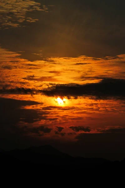 山の上の雲の間からの夕日 — ストック写真