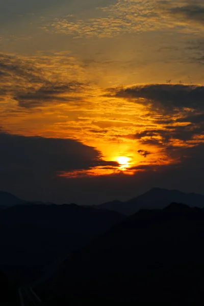 Ηλιοβασίλεμα Ανάμεσα Στα Σύννεφα Πάνω Από Βουνά — Φωτογραφία Αρχείου