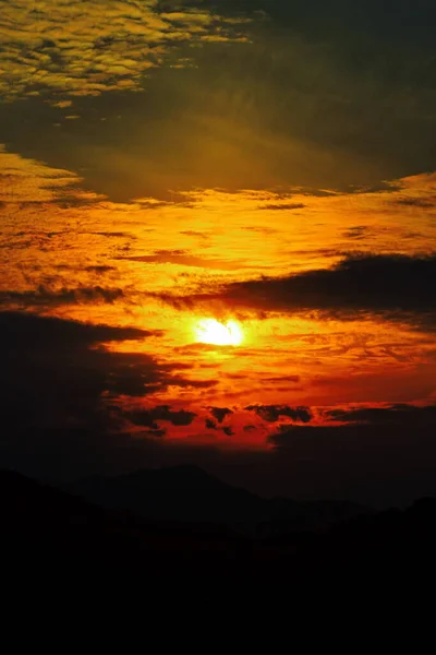 山の上の雲の間からの夕日 — ストック写真