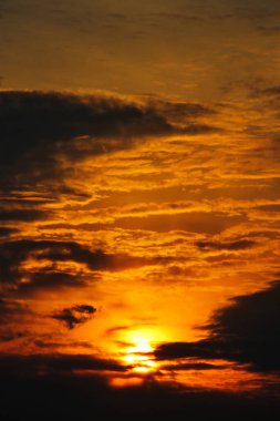 Dağların üzerinde bulutların arasında gün batımı