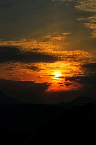 山の上の雲の間からの夕日 — ストック写真