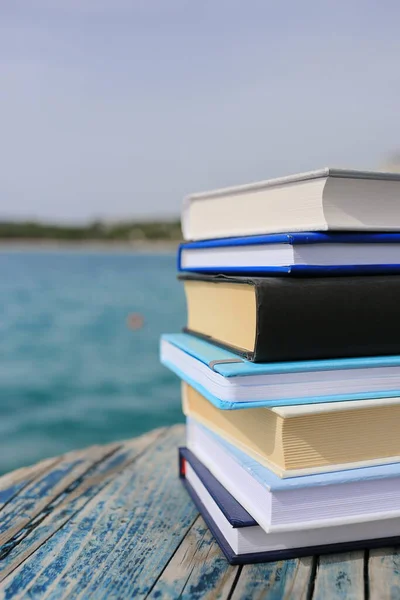 Stack of books on the beach by the sea