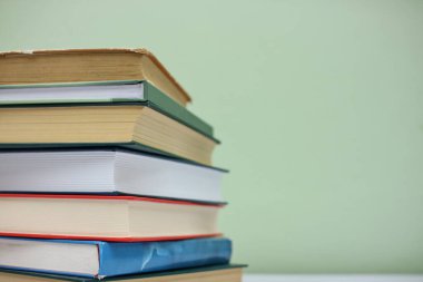 Yeşil arkaplan üzerine kitap yığını