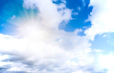 Küçük bulutlar ve güneş ışığı ile mavi gökyüzü arka planı