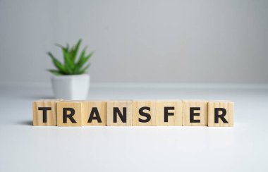 Parlak bir ofisteki ahşap bir masaya transfer tabelası..