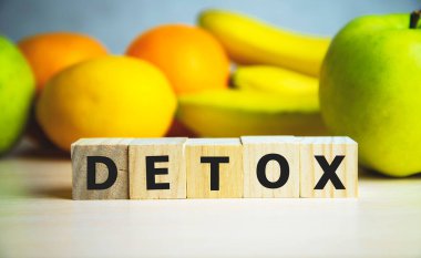 Arkaplanda meyveli tahta küplerin üzerindeki detoks metni