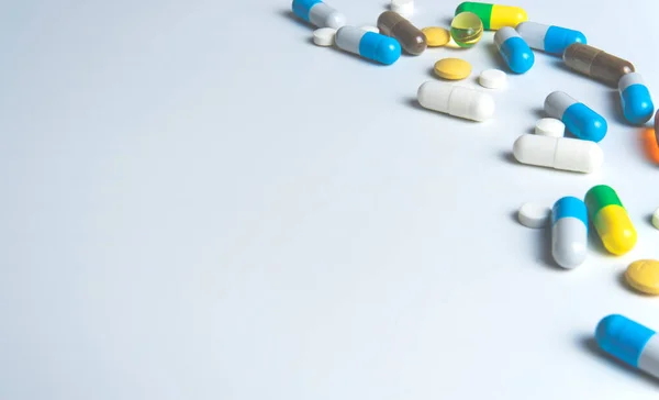 Pillen sind auf weißem Hintergrund verstreut, medizinisches Konzept. — Stockfoto