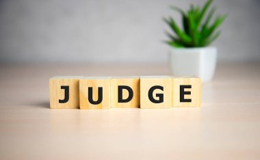 Kelimelerle bloklama. Masadaki tahta küplerle yargılama.