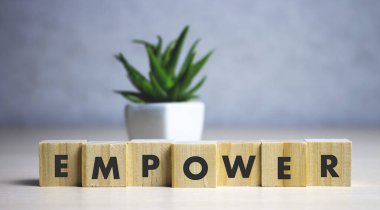 empower word written on wood block. empower text on table, concept clipart