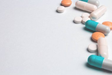 Beyaz üzerine mavi, turuncu ve beyaz haplar.