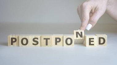 Ertelendi - ahşap bloklardan harflerle el ele tutuşmalar, ertelenmiş kavram, üst görünüm arka plan