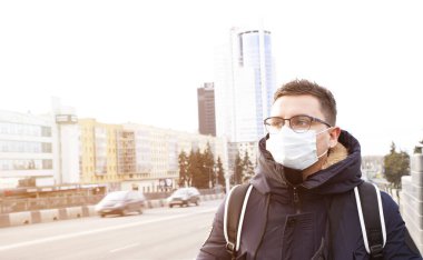 Şehir merkezinde ceketli moda adamının portresi. İş konsepti. Yüzünde maske olan yakışıklı, mutlu bir insan..