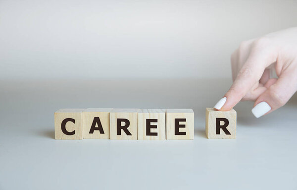 Career adviser assembling the word career with six wooden cubes in a conceptual image of personal guidance towards self realization