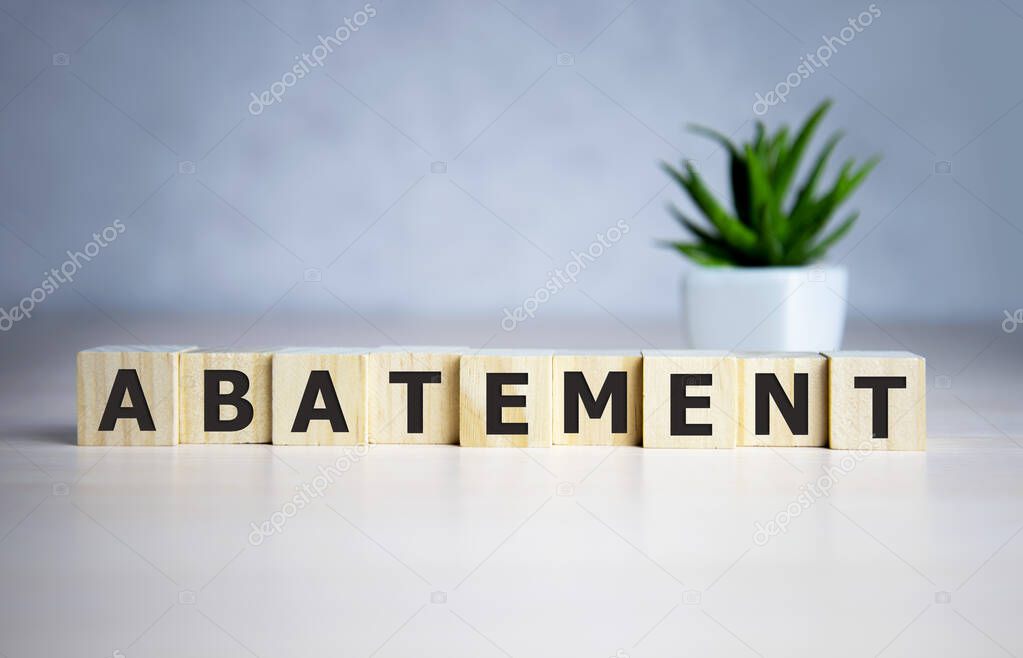 The word ABATEMENT written on wooden cubes on a blue background.