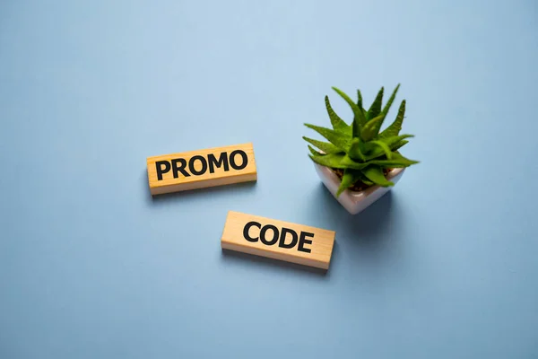 Promocode - word from wooden blocks with letters, coupon, promotion code, promo code concept, top view on blue background.