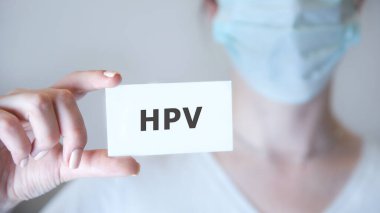 Üzerinde HPV yazan bir tabela gösteren bir doktor..