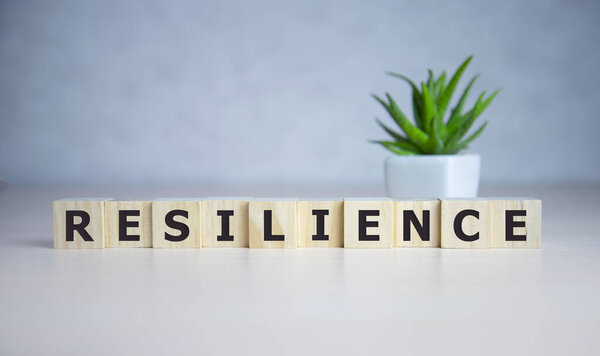 Resilience word concept on cubes on blue background