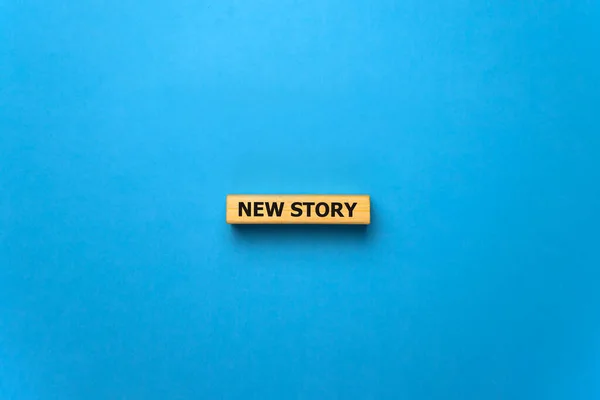 New story - phrase from wooden blocks with letters, Personal History Achievement Biography My story concept, blue background.