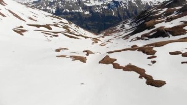 Uçan dağcı, karlı dağın zirvesine doğru yürüyor, dağlarda kayak turu yapıyor. 