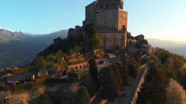 Eski ortaçağ manastırında uçan İHA gündoğumunda dağın tepesine tünedi, Torino İtalyan Alpleri