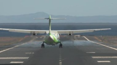 Jetliner geliyor. Deniz kenarındaki piste inen uçak.