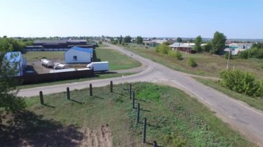 Çitin arkasındaki binalarla bira imalatının avlusuna giden Tank kamyonlarının hava görüntüsü