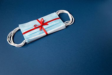 Üst görünüm tıbbi koruyucu maskeler kırmızı kurdeleli ve mavi arkaplanda kopyalama alanı olan