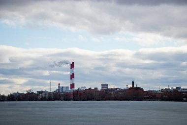 Sanayi üretiminin panoramik görüntüsü bulutlu havada suyun yanında yer alıyor