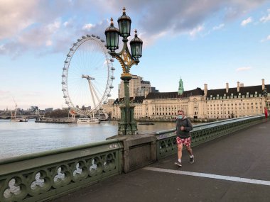 A man jogging doing daily exercise in the mask in empty London during quarantine March, April and May 2020 clipart