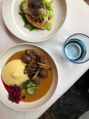 Lezzetli geleneksel İsveç köfteleri patates püresi, mantar sosu, et suyu ve yaban mersini reçeli ile servis edilir.