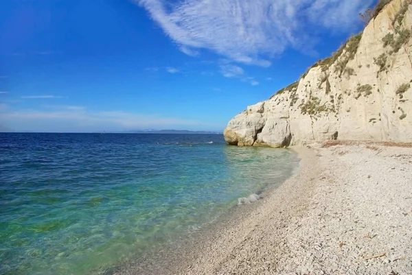 Beyaz çakıl taşlarının plajı yüksek beyaz bir uçurumun altında, güzel bir suyun önünde (Capo Bianco, Elba Adası, İtalya)