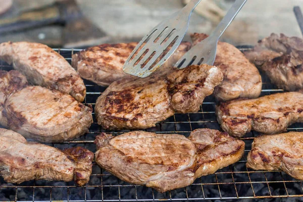 to cook meat on the coals on the grate of the grill