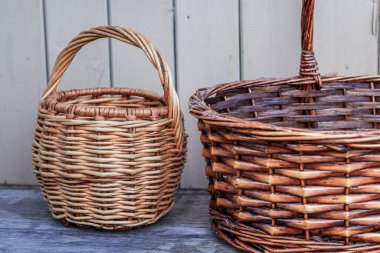 Bir ahşap zemin üzerinde iki hasır sepet, bir küçük ve bir büyük.