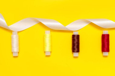 Mavi arka planda beyaz renkler, makas açık, ve turkuaz kurdele dikmek için, beyaz, mavi, yeşil, pembe, sarı iplik mavi arkaplanda, kopyalama alanı, üst görünüm