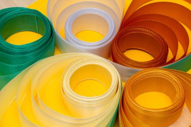 Sarı arkaplanda çok renkli kıvrımlı kurdele, üst görünüm, doku