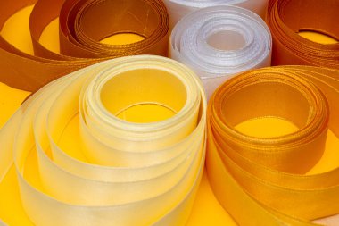 Sarı arkaplanda çok renkli kıvrımlı kurdele, üst görünüm, doku