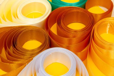 Sarı arkaplanda çok renkli kıvrımlı kurdele, üst görünüm, doku