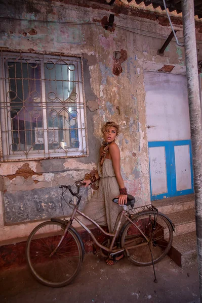 Bej tulumlu, eski bir bisikletle Hindistan 'ın eski caddesinde...