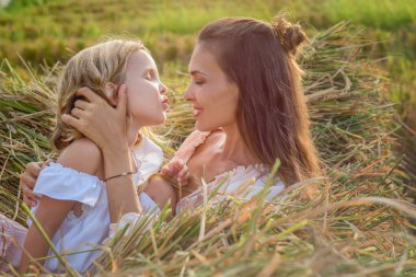 Güzel esmer anne, tarlada narin sarışın bir kızı var.