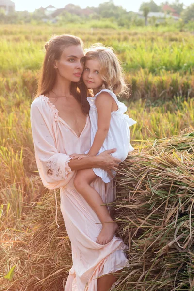Güzel esmer anne, tarlada narin sarışın bir kızı var.