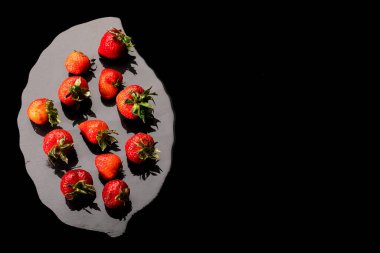 Çilekler ıslak siyah taş tepside fotokopi alanı ile