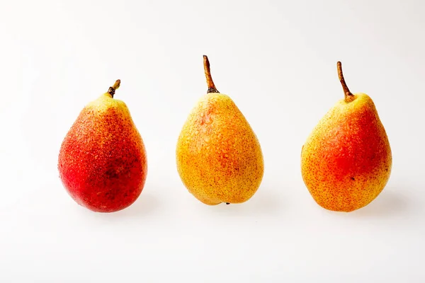 Three yellow-red ripe pears on a white background